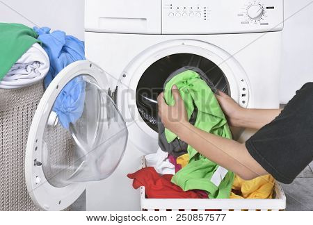 Male Loading Dirty Clothes From Basket To Washing Machine For Washed. Home Appliance