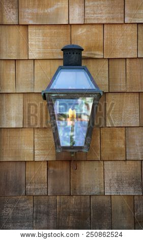 Gas Flame Porch Light on a Cedar Shake Wall. Cedar Shake. Cedar Shake Background. Wood Shake Wall. Backgrounds and Wallpapers. Room for text.
