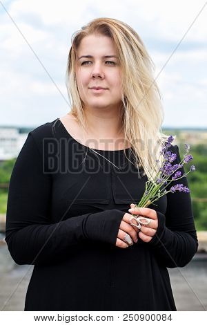 Young Beautiful Woman In A Black Dress With A Bouquet Of Lavender