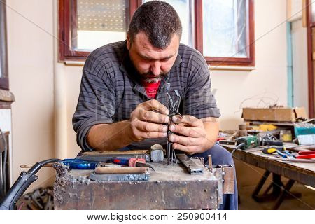 Sculptor Is Giving Stance, Attitude To His Figures Made Of Metal Wire In His Workshop.