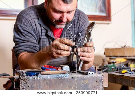 Sculptor Is Giving Stance, Attitude To His Figures Made Of Metal Wire In His Workshop.