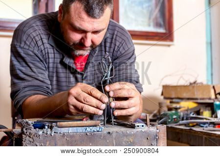 Sculptor Is Giving Stance, Attitude To His Figures Made Of Metal Wire In His Workshop.