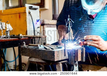 Sculptor Is Using Arc Welding To Assembly Metal Sculpture Without Proper Protection, Barehanded.