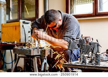 Sculptor Is Using Arc Welding To Assembly Metal Sculpture Barehanded With Protective Spectacles.