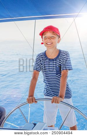 Cute Boy On Board Of Sailing Yacht On Summer Cruise. Travel Adventure, Yachting With Child On Family