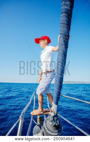 Cute Boy On Board Of Sailing Yacht On Summer Cruise. Travel Adventure, Yachting With Child On Family