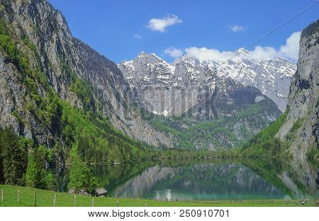Green Mountain Lake Mittersee. Mirroring The Alpine Snow-capped Peaks.