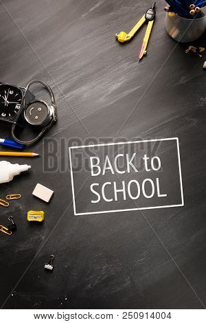 School Supplies, Alarm Clock, Pencils On Black Chalkboard Top View, Copy Space, Vertical Framing. Te