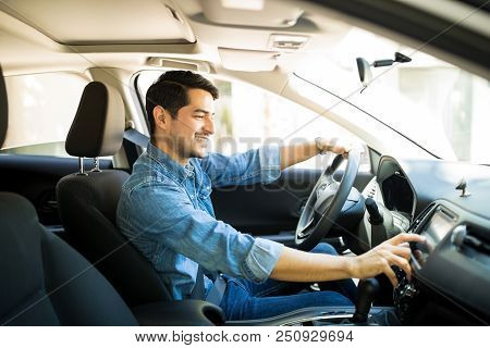 Handsome Young Man In Denim Shirt Pressing Touchscreen On Car Multimedia Panel, Switching Shifting R