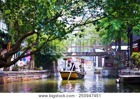 Shanghai, Zhujiajiao, China, July 2015. A Boat With Boatman And Tourists On The Tree-covered Canal I