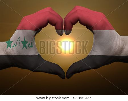 Heart And Love Gesture By Hands Colored In Iraq Flag During Beautiful Sunrise