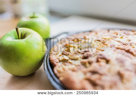 Freshly Baked Apple Pie And Two Fresh Green Apples On A Light Wooden Background