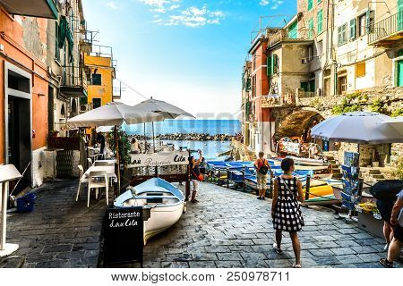 Riomaggiore, Italy - September 18 2017: Tourists Enjoy A Sunny Day On The Ligurian Coast With The Se