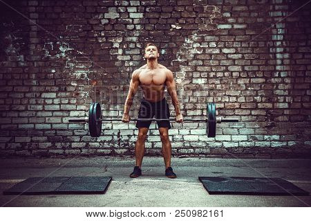 Muscular Fitness Man Doing Deadlift A Barbell Over His Head In Outdoor, Street Gym. Functional Train
