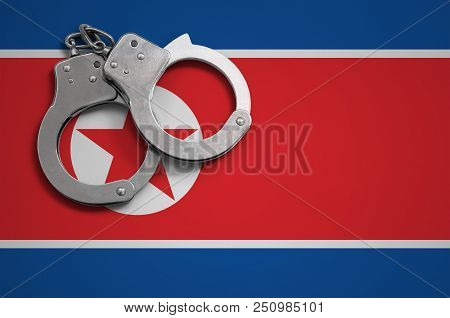 North Korea Flag  And Police Handcuffs. The Concept Of Crime And Offenses In The Country.