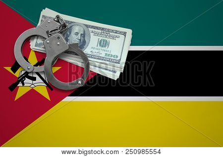 Mozambique Flag  With Handcuffs And A Bundle Of Dollars. The Concept Of Breaking The Law And Thieves