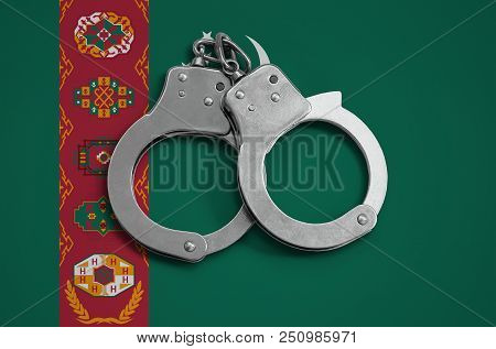 Turkmenistan Flag  And Police Handcuffs. The Concept Of Observance Of The Law In The Country And Pro