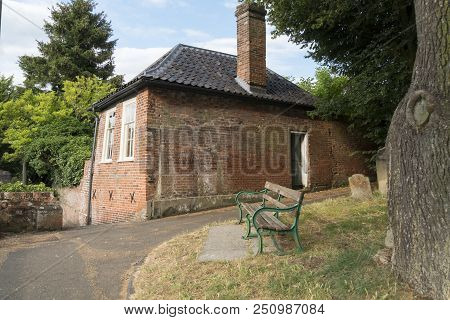 Historic Cottage And Bench In The Evening Sunshine