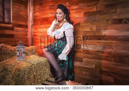Portrait Of Fat Plump Fun Charming Cute Woman With Black Curly Hair In The Room With Hay And Straw