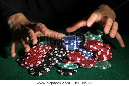 Poker fişleri ve yeşil masa üstündeki elleri
