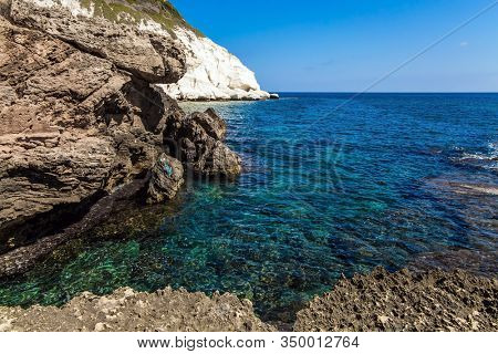 The border between Israel and Lebanon. Rocky bay near chalk mountain Rosh a Nikra in northern Israel. The color of sea water from azure to dark blue. The concept of eco and photo tourism