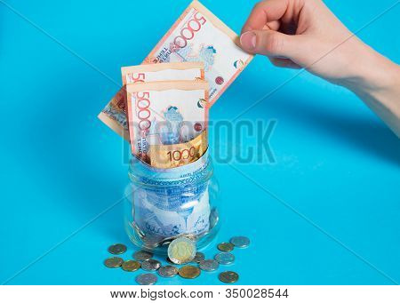 Get Tenge Out Of A Glass Jar. Put Money In A Glass Jar. Kazakhstan, Kz, Kzt. Banknote, Paper Currenc