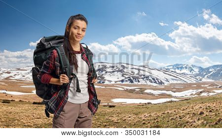 Young female hiker with a backpack on a mountain 