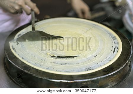 Cooking Thai Pancakes: The Cook Rolls The Dough With A Spatula On A Hot Pancake Pan. Traditional Str