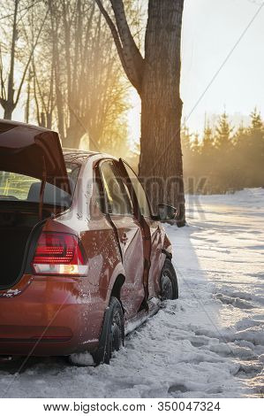 Car And Ice On The Winter Road. The Car Had An Accident In The Winter, Crashed Into A Tree And Slid 