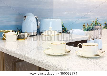 Beautiful set with cups on the bar counter. Background in blur. With household appliances