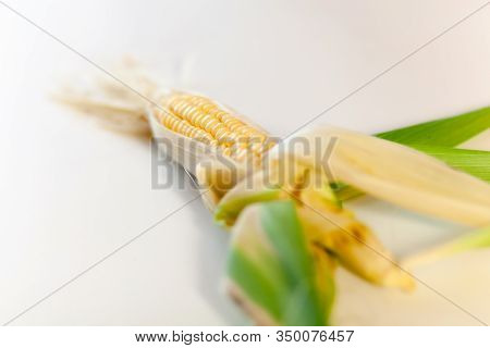 Posing Corn On A Wooden White Table