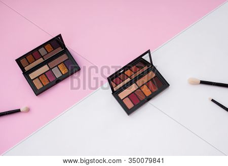 Two Colorful Eyeshadow Palletes And Natural Makeup Brushes On White And Pink Background. Especially 
