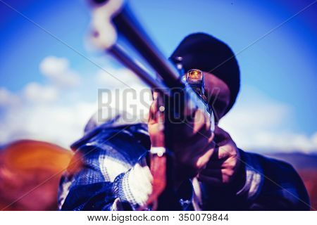 Hunter Aiming Rifle In Forest. Hunter With Shotgun Gun On Hunt. Autumn Hunting Season. Barrel Of A G