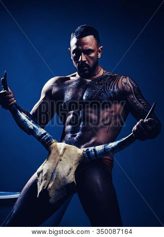 High Testosterone Level. Strong Hispanic Man Full Of Testosterone And Desire Holding Skull And Horns