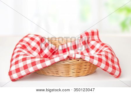 Wicker Basket With A Red Checkered Napkin On The Table
