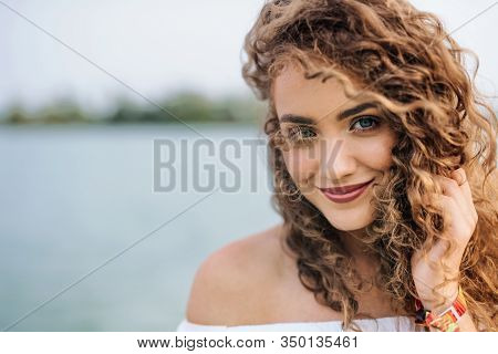 Front View Portrait Of Young Woman Standing Outdoords In Summer.