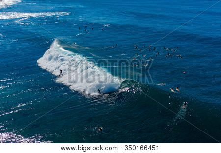 Surfers Waiting For The Big Wave In The Sea At Banzai Pipeline On North Coast Of Oahu, Hawaii