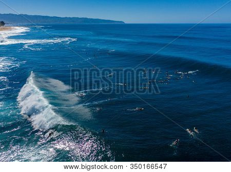 Surfers Waiting For The Big Wave In The Sea At Banzai Pipeline On North Coast Of Oahu, Hawaii