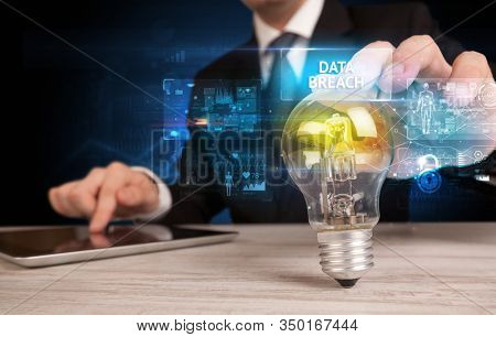 Businessman holding lightbulb with DATA BREACH inscription, online security idea concept