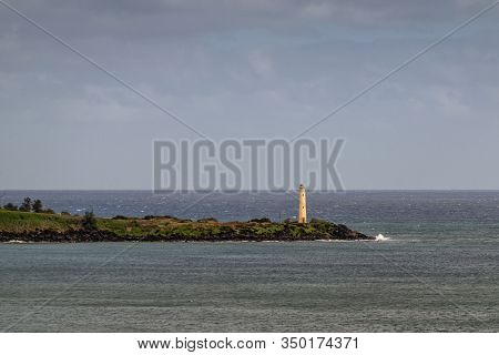 Nawiliwili, Kauai, Hawaii, Usa. - January 17, 2020: Yellow Ninini Lighthouse On Black Ocean-shore Ro