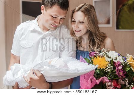 Portrait Of Young Parents With Their Newborn Firstborn.