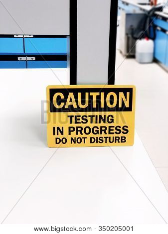 Caution Testing In Progress Do Not Disturb, A Safety Sign Warning On Bench Laboratory, Useful For Ca