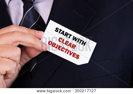 Businessman Putting A Card With Text Start With Clear Objektives In The Pocket