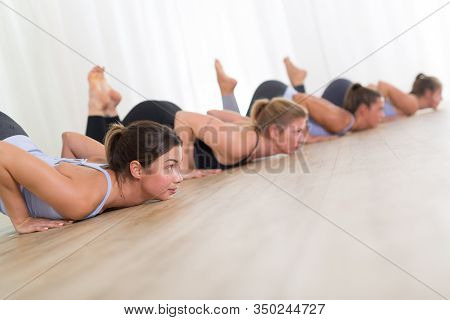 Group Of Young Sporty Sexy Women In Yoga Studio, Practicing Yoga Lesson With Instructor, Forming A L