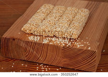 Honey Bars With Sesame Seeds Close-up On Wooden Background. Gozinaki Sweets. Traditional Oriental Co