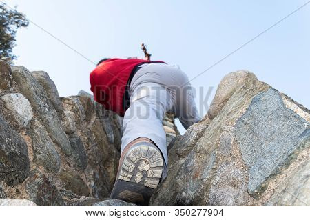 Man Climbing With His Foot In The Foreground On Rock