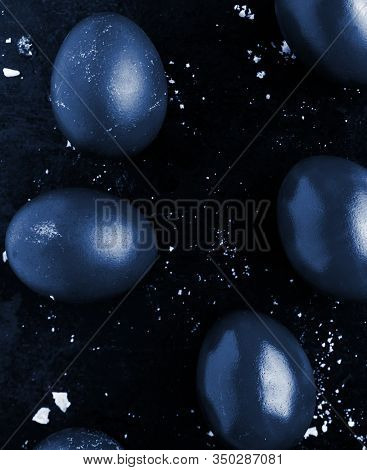 Easter Eggs Painted In Classic Blue Monochrome Style Close Up On A Black Surface With Icing Crumbs.