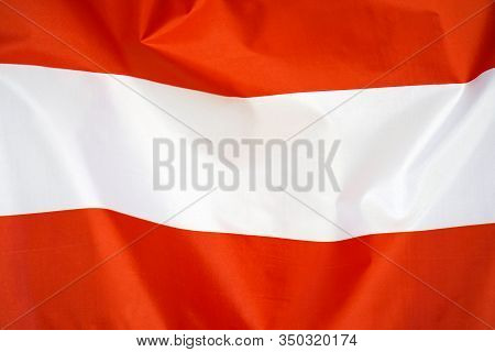 Fabric Texture Flag Of Austria. Flag Of Austria Waving In The Wind. Austria Flag Is Depicted On A Sp
