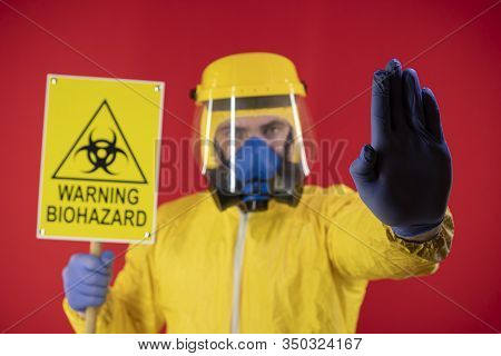 A Man In A Protective Chemical Mask And A Protective Yellow Suit With A Banner In His Hand With The 
