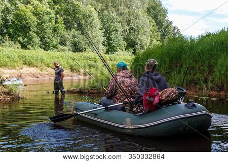Tuzha, Russia - June 15, 2019: Fishermen Catch Fish On A Rubber Boat On A Forest River. Pizhma River